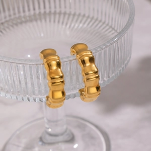 Dettaglio orecchini a C con trama a bambù placcati oro 18K su bordo di vetro