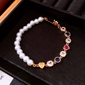 Détail du bracelet de perles plaqué or 18 carats avec breloques cœur en cristal coloré