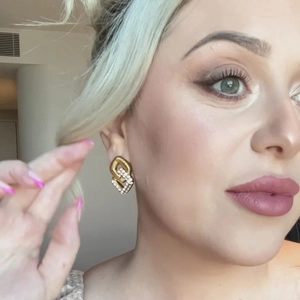 Close-up of 18K gold-plated cubic zirconia earrings worn on a female model face