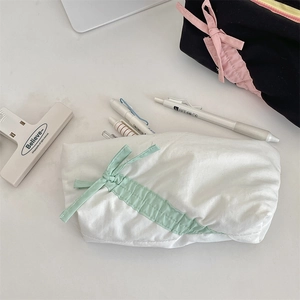 Dettaglio dell'astuccio in morbido cotone con fiocco verde menta e trama del tessuto