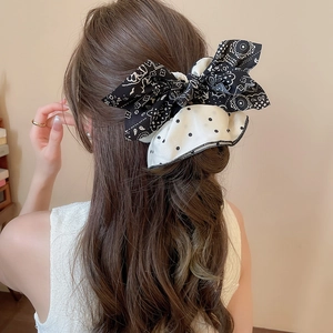 Détail d'un grand nœud papillon en tissu à pois et imprimé ethnique sur un chignon
