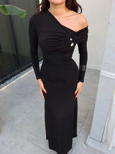 Detail of the elegant single-shoulder neckline with pleats and a white pearl button decoration