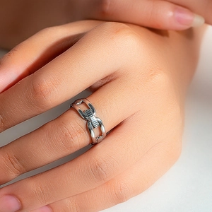 Detailed view of silver chain link ring on finger, highlighting geometric metal design