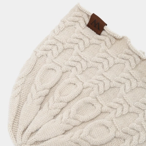 Bonnet en tricot torsadé crème pour femme avec écusson en cuir en gros plan