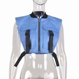 Detail view of blue utility vest with black buckle straps and contrast stand collar
