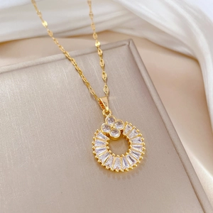 Macro shot of gold-plated clover necklace with micro-pave zirconia crystals in a gift box