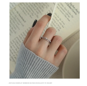 Macro detail of a double-layered S925 silver ring with zircon stones worn on hand