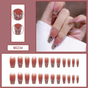 Detail of pink gradient press-on nails with silver glitter tips and rhinestone accents