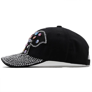 Détail d'une casquette en denim noir avec strass scintillants et cristaux multicolores