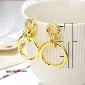 Detail of hollow copper triple-hoop earrings with 18k gold plating on ceramic cup