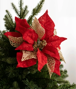 Close-up of a 27cm red and gold velvet poinsettia flower on a Christmas tree branch