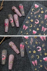 Detail of pink butterfly and gold star nail decals applied on artificial nails