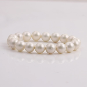 Minimalist pearl bracelet for women featuring round cream white pearls on a white surface