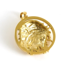Macro detail of gold 3D Jesus head pendant with thorns and polished metal finish