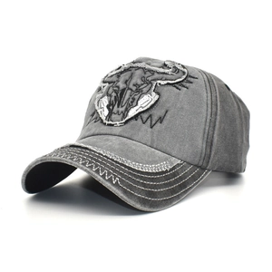 Detail of bull skull embroidery on washed cotton baseball cap with distressed brim finish