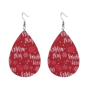Close-up of red leather teardrop earrings with Merry Christmas print and snowflake details