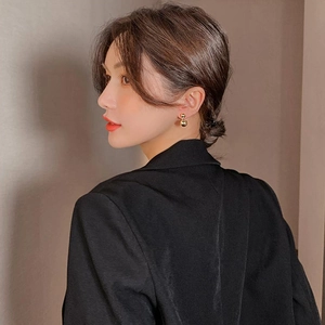 Side view of model wearing gold double-bead geometric earrings with metallic texture