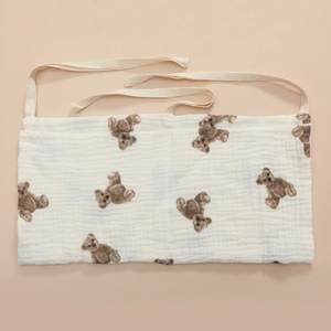 Close-up of muslin cotton bedside organizer featuring brown teddy bear print and ties