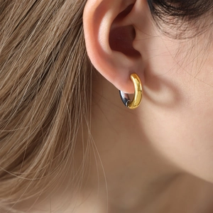 Two-tone geometric gold and silver hoop earring on model with a minimalist modern style