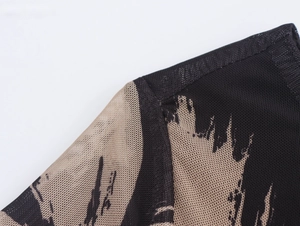 Detailopname van beige en zwarte mesh-stof met bloemenprint op de jurk met lange mouwen