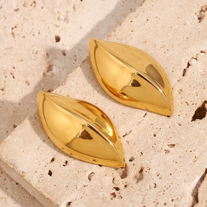 Macro shot of abstract leaf-shaped 18K gold plated stainless steel earrings on stone