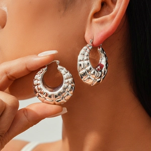 Chic silver metal hoop earrings with embossed grid texture shown on model