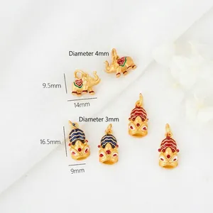 Golden Lion and Elephant enamel pendants on white texture with floral accents