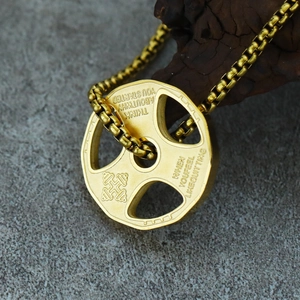 Macro detail of golden dumbbell pendant with motivational quote on a stone background