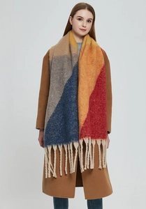 Detailed view of color-block scarf with chunky tassels on brown coat background