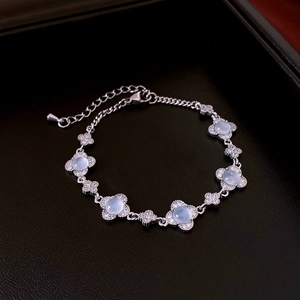 Dettaglio macro del bracciale a fiori in argento con pietre blu e cristalli su pelle