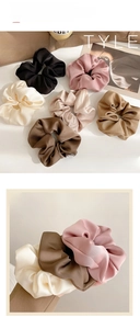 Detail of satin scrunchies in minimalist fall colors like black, beige and soft pink