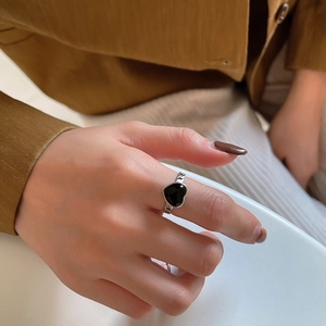 Detail of a 925 silver ring featuring a black heart stone and vintage chain texture