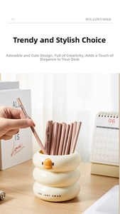 Close-up of cream swan pencil holder with natural wood pencils on a minimalist desk