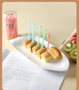 Close-up of colorful plastic fruit forks in macaron tones for desserts and snacks