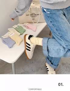 Détail macro de chaussettes en maille côtelée macaron portées avec jean et baskets