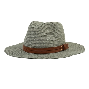 Detail of dark gray straw Panama hat featuring a brown leather band with gold rivets