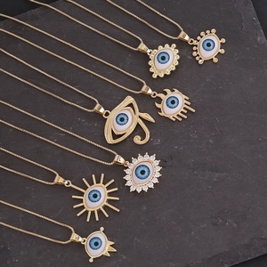 Détails de sept colliers dorés avec pendentifs mauvais œil sur fond de roche noire