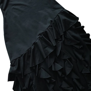 Détail de volants asymétriques multicouches et fente latérale sur robe de soirée noire