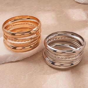 8-piece set of geometric textured metal bangles in gold and silver finish on stone