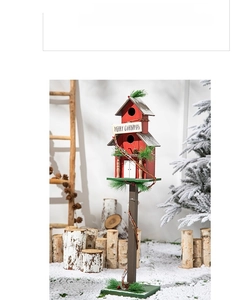 Close-up of wooden Christmas birdhouse garden stake with pine needles and red berries