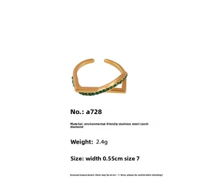 Detail view of V-shaped stainless steel ring with green cubic zirconia and gold plating