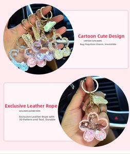 Close-up of sakura shaped liquid glitter keychain with floating sequins and gold metal ring