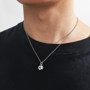 Men's stainless steel football pendant necklace with polished silver finish on model