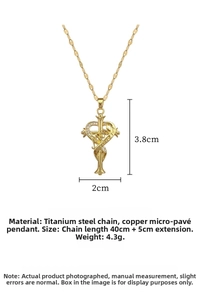 Detail of gold heart cross pendant with MOM engraving and crystals on titanium chain