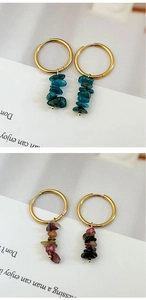 Close-up of gold stainless steel hoop earrings with natural red and blue stone beads