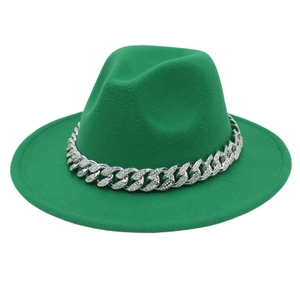 Close-up of bright green fedora hat featuring a silver Cuban chain and sparkling rhinestones