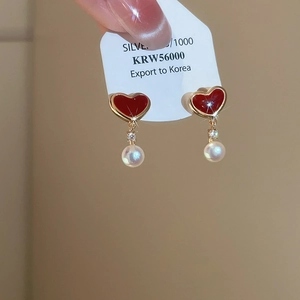 Detail of S925 silver earrings featuring red enamel hearts and white round pearls