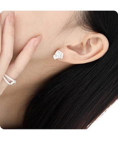Close-up of irregular pleated S925 sterling silver earrings and ring on female model
