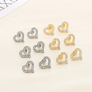 Detail view of heart-shaped earrings in gold and silver finish with sparkling rhinestones