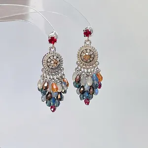 Gros plan détaillé de boucles d'oreilles bohèmes avec cristaux et perles facettées